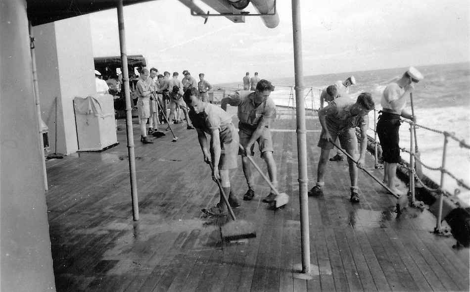 Royal Canadian Navy : Holystoning the deck on HMCS Prince Robert.